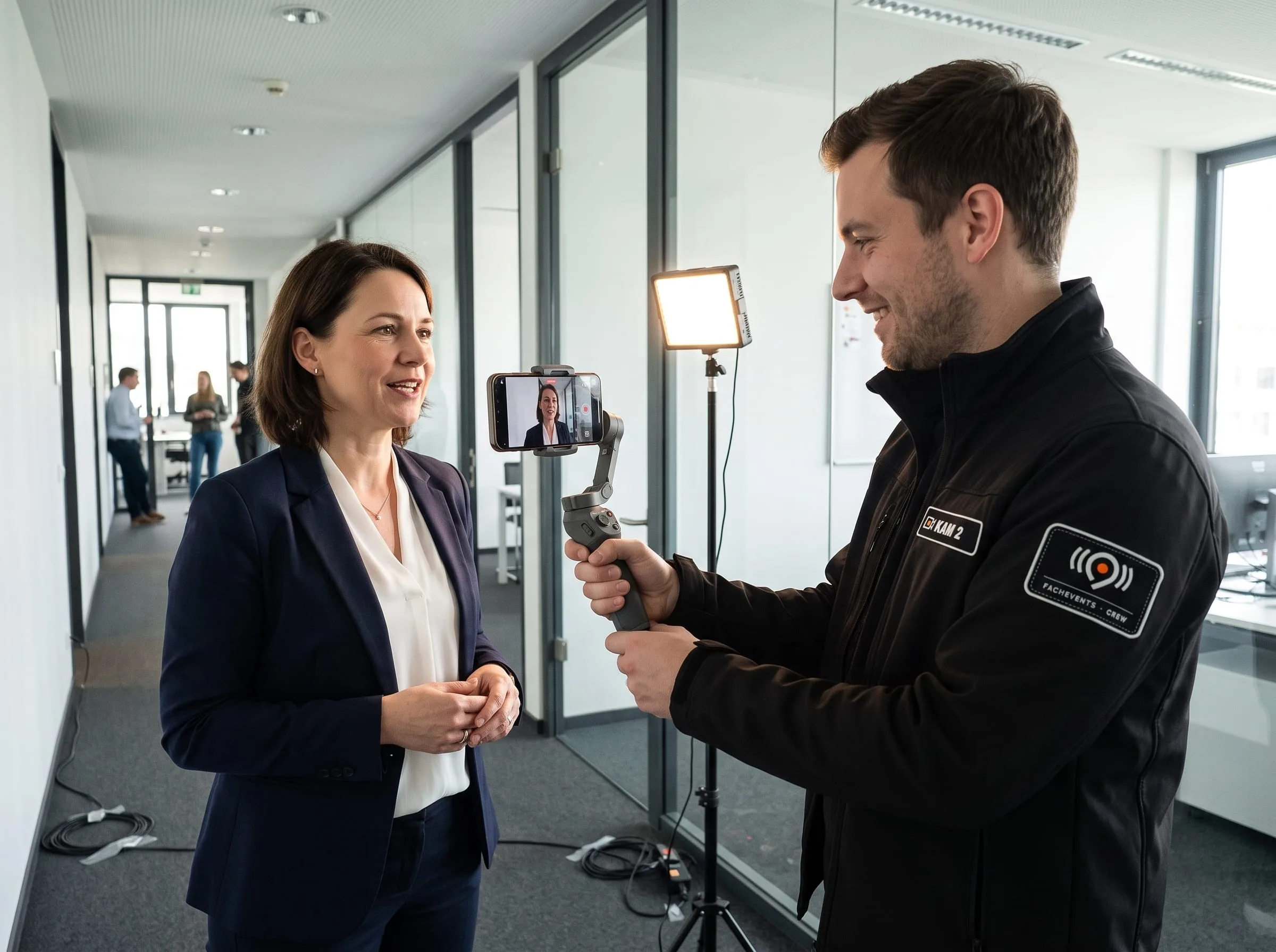 Teaser-Video für die Einladung: Ein Videograf filmt eine Expertin mit dem Smartphone am Gimbal