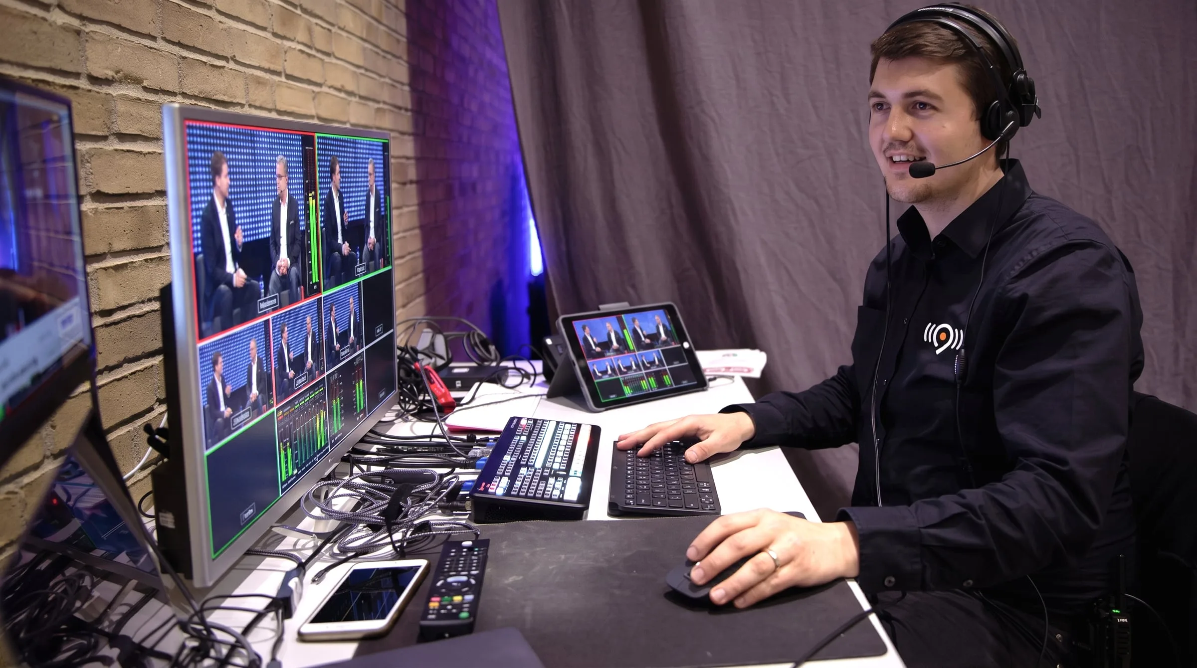 Justus Kornath am Regieplatz mit Headset und Multiview-Monitor während einer Live-Produktion